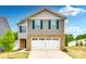 Charming two-story home featuring a brick facade, gray siding, blue shutters, and a pristine white garage door at 5014 Fandango Rd, York, SC 29745