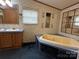 Bathroom featuring a large bathtub, vanity with sink, and decorative mirrors at 51 Kings Dr, Taylorsville, NC 28681