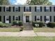 Exterior view of a multi-Gathering building with black shutters and landscaped front yard at 557 Wakefield Dr # A, Charlotte, NC 28209