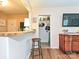 An open living area with hardwood floors, a bar top, and access to a pantry and comfortable seating at 557 Wakefield Dr # A, Charlotte, NC 28209
