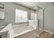 Bright bathroom with a bathtub and walk-in shower at 5716 Langwell Ln, Charlotte, NC 28278