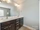 Bright bathroom with double sink vanity and dark wood cabinets at 5716 Langwell Ln, Charlotte, NC 28278