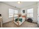 A bright bedroom featuring a wooden four poster bed and large windows at 5716 Langwell Ln, Charlotte, NC 28278
