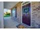 Charming brick home entrance featuring a dark wood door adorned with a green wreath at 5716 Langwell Ln, Charlotte, NC 28278