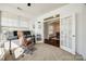 Bright office features a comfortable chair and French doors leading to the dining room at 5716 Langwell Ln, Charlotte, NC 28278