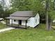 Charming one-story home with a covered porch and a lush, green yard at 59 Pine St, Great Falls, SC 29055
