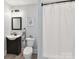 Neutrally decorated bathroom featuring a curtained shower, modern toilet, vanity, and accent mirror at 633 Elmhurst Dr, Fort Mill, SC 29715