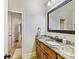 Bathroom with wood cabinets, granite counters, decorative mirror, and access to toilet and shower at 633 Elmhurst Dr, Fort Mill, SC 29715
