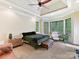Primary bedroom with tray ceiling, comfortable seating, multiple windows and natural light at 633 Elmhurst Dr, Fort Mill, SC 29715