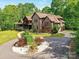 Beautiful brick home featuring a circular driveway and lush landscaping in a serene setting at 633 Elmhurst Dr, Fort Mill, SC 29715