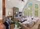 Inviting living room featuring a stone fireplace, high ceilings, and large windows overlooking the greenery at 633 Elmhurst Dr, Fort Mill, SC 29715