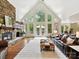 Spacious living room boasts a stone fireplace, hardwood floors, and a wall of windows overlooking the backyard at 633 Elmhurst Dr, Fort Mill, SC 29715