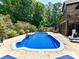 Beautiful backyard pool with clean blue water, surrounded by a concrete patio and lush landscaping at 633 Elmhurst Dr, Fort Mill, SC 29715