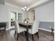 Elegant dining room featuring stylish furniture, a modern chandelier, and French doors leading to another area for entertaining at 653 Gable Oaks Nw Ln, Concord, NC 28027