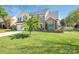 Charming two-story home with a manicured lawn and a combination of brick and siding exterior under a clear blue sky at 653 Gable Oaks Nw Ln, Concord, NC 28027