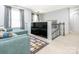 Cozy loft area with soft blue sofa, large television, and stylish carpet, creating a relaxing retreat at 653 Gable Oaks Nw Ln, Concord, NC 28027