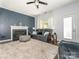 Comfortable living room with a fireplace, stylish furniture, plush carpet, and a ceiling fan for optimal comfort at 653 Gable Oaks Nw Ln, Concord, NC 28027