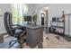 Home office with a large desk, comfortable chair, ample workspace, and natural light creating an inspiring work environment at 653 Gable Oaks Nw Ln, Concord, NC 28027