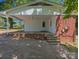 Back exterior with large covered patio with brick foundation and concrete parking pad at 805 Mark Dr, Shelby, NC 28152