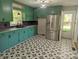 Bright kitchen featuring vibrant green cabinetry, stainless steel appliances, and starburst patterned floor at 805 Mark Dr, Shelby, NC 28152