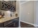 Wet bar featuring stone countertop, tiled backsplash, dark cabinets, and a wine rack at 826 Coralbell Way, Fort Mill, SC 29708