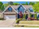 Charming two-story home with stone accents, manicured lawn, and mature landscaping at 826 Coralbell Way, Fort Mill, SC 29708