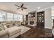 Cozy living room featuring a stone fireplace, built-in bookshelves, and hardwood flooring at 826 Coralbell Way, Fort Mill, SC 29708