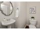 Stylish powder room with pedestal sink, toilet, modern fixtures, and attractive decor at 10102 Tolleson Ave, Charlotte, NC 28277