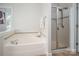 Bright bathroom featuring a large soaking tub, glass enclosed shower, and neutral color palette at 10102 Tolleson Ave, Charlotte, NC 28277
