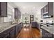 Open kitchen design with granite countertops, grey cabinets, and eat-in dining area at 10102 Tolleson Ave, Charlotte, NC 28277