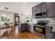 Modern kitchen featuring grey cabinets, stainless steel appliances, and hardwood floors at 10102 Tolleson Ave, Charlotte, NC 28277