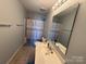 Simple bathroom showcasing a single sink vanity, tile floors, and a shower/tub combination with a modern shower curtain at 1110 Valley St, Statesville, NC 28677