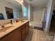 Bright bathroom featuring double sinks, a mirror, tile floors, and a shower/tub combination with a curtain at 1110 Valley St, Statesville, NC 28677