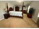 Traditional main bedroom featuring a dark wood four-poster bed, matching furniture, and neutral carpeting at 1110 Valley St, Statesville, NC 28677