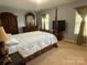 Cozy main bedroom features a four-poster bed, neutral carpeting, and ample natural light from the windows at 1110 Valley St, Statesville, NC 28677