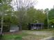 Charming home with a screened in porch, storage shed, and landscaped yard on a treed lot at 124 Hummingbird Cir, New London, NC 28127