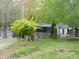Landscaped yard with windmill, storage shed, porch, and mature trees at 124 Hummingbird Cir, New London, NC 28127