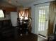 Bright dining area with table set up next to the kitchen with backyard view and a light fixture at 124 Hummingbird Cir, New London, NC 28127