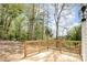 Wood deck offers space for outdoor entertaining, with natural wood railing and beautiful mature trees in the backyard at 1314 Eddie St, Gastonia, NC 28054