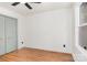 Bedroom features wood flooring, a ceiling fan, a window overlooking trees, and a closet with decorative doors at 1314 Eddie St, Gastonia, NC 28054