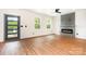 Spacious living room featuring an electric fireplace, wood-look floors, and abundant natural light from the exterior door and windows at 1314 Eddie St, Gastonia, NC 28054