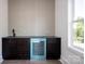 Modern bar area with dark cabinets, sink, and light blue beverage cooler near a window at 139 Poplar Grove Rd, Mooresville, NC 28117