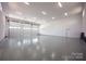 A spacious garage features three roll-up doors and a light grey epoxy-coated floor for a modern look at 139 Poplar Grove Rd, Mooresville, NC 28117