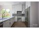 Bright kitchen features stainless steel appliances, gray backsplash and white cabinets and countertops at 139 Poplar Grove Rd, Mooresville, NC 28117