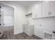 Bright laundry room includes sink, white cabinets, and doorway to another room at 139 Poplar Grove Rd, Mooresville, NC 28117