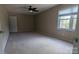 This bedroom features neutral walls, carpet flooring, and a ceiling fan, illuminated by natural light from a window at 1404 Oakdale Rd, Rock Hill, SC 29730