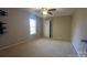 This carpeted bedroom features neutral walls, a ceiling fan, a window, and a closet door at 1404 Oakdale Rd, Rock Hill, SC 29730