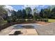 Backyard pool with cover surrounded by lush landscaping and beautiful trees at 1404 Oakdale Rd, Rock Hill, SC 29730