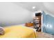 Bedroom with light yellow bedding, sloped ceilings, and storage solutions for organization at 141 Rose St, Mooresville, NC 28117