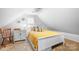Cozy bedroom featuring sloped ceilings, a white bed with yellow comforter, and neutral decor at 141 Rose St, Mooresville, NC 28117
